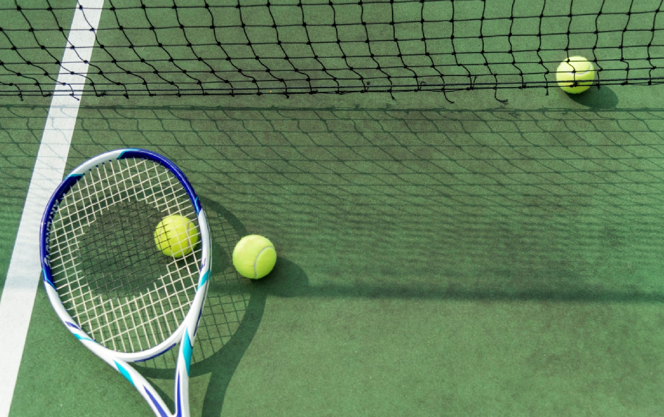 Tennis racket laying on a tennis court