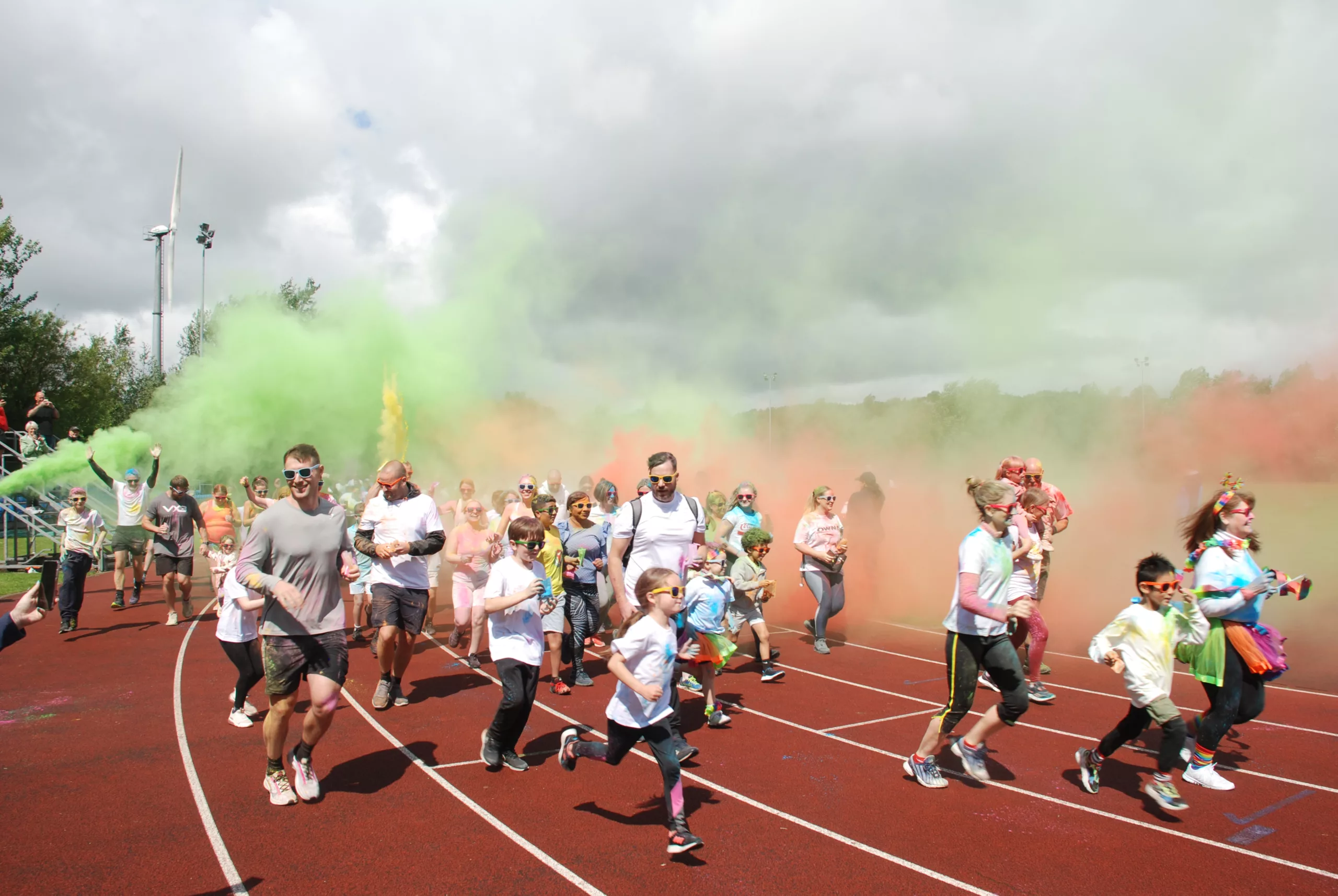 Adults and children participating in Bolton Arena colour run 2023