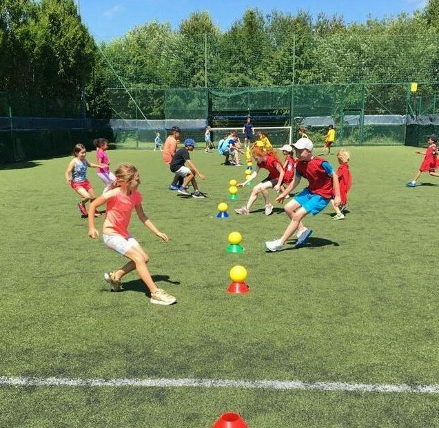 Children playing sports games outside at Bolton Arena