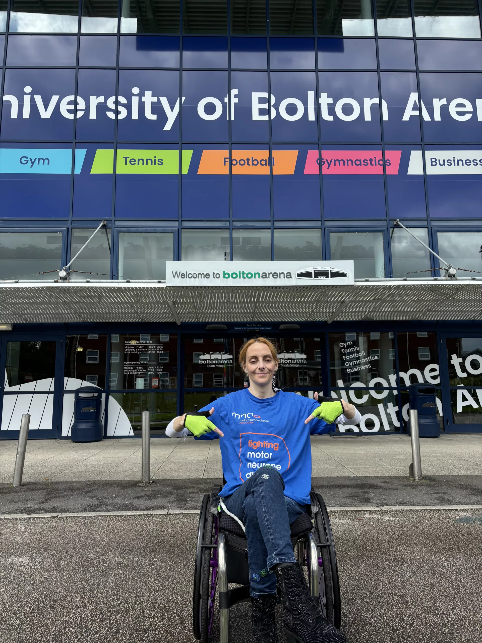 Who can put Natalie on the road to £5k fundraiser for MND research? 1 Natalie Amber outside Bolton Arena, pointing are her MND top.